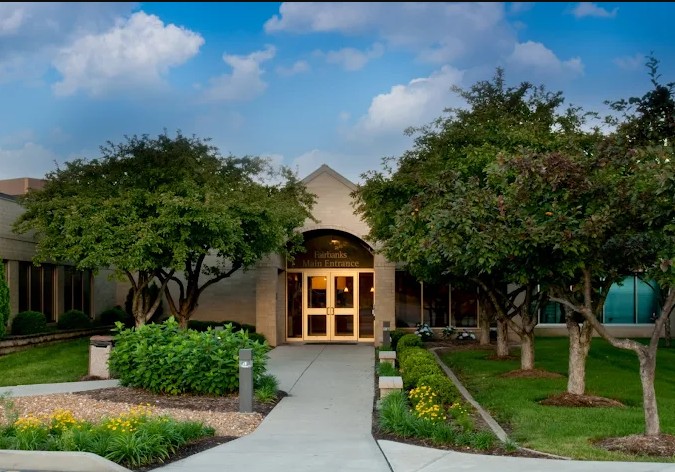 Facility main entrance with landscaped walkway and trees