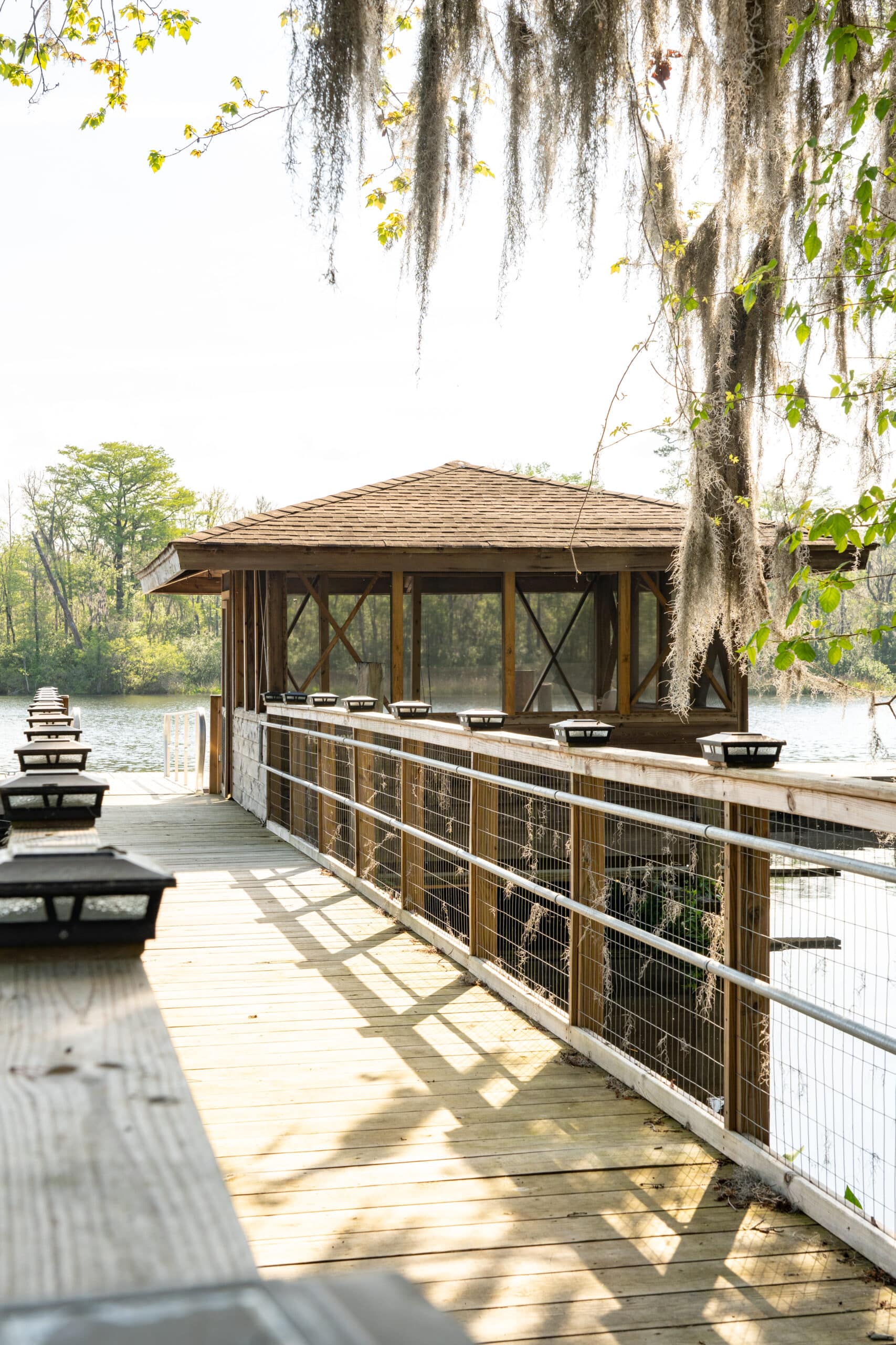 Wooden dock leading to a covered lakeside pavilion
