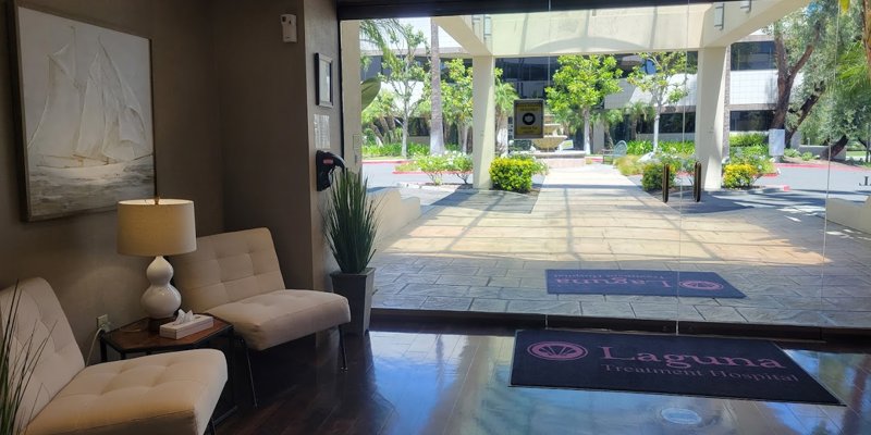 A welcoming lobby area with cozy seating, warm lighting, and a view of a lush outdoor courtyard, creating a serene and inviting atmosphere.