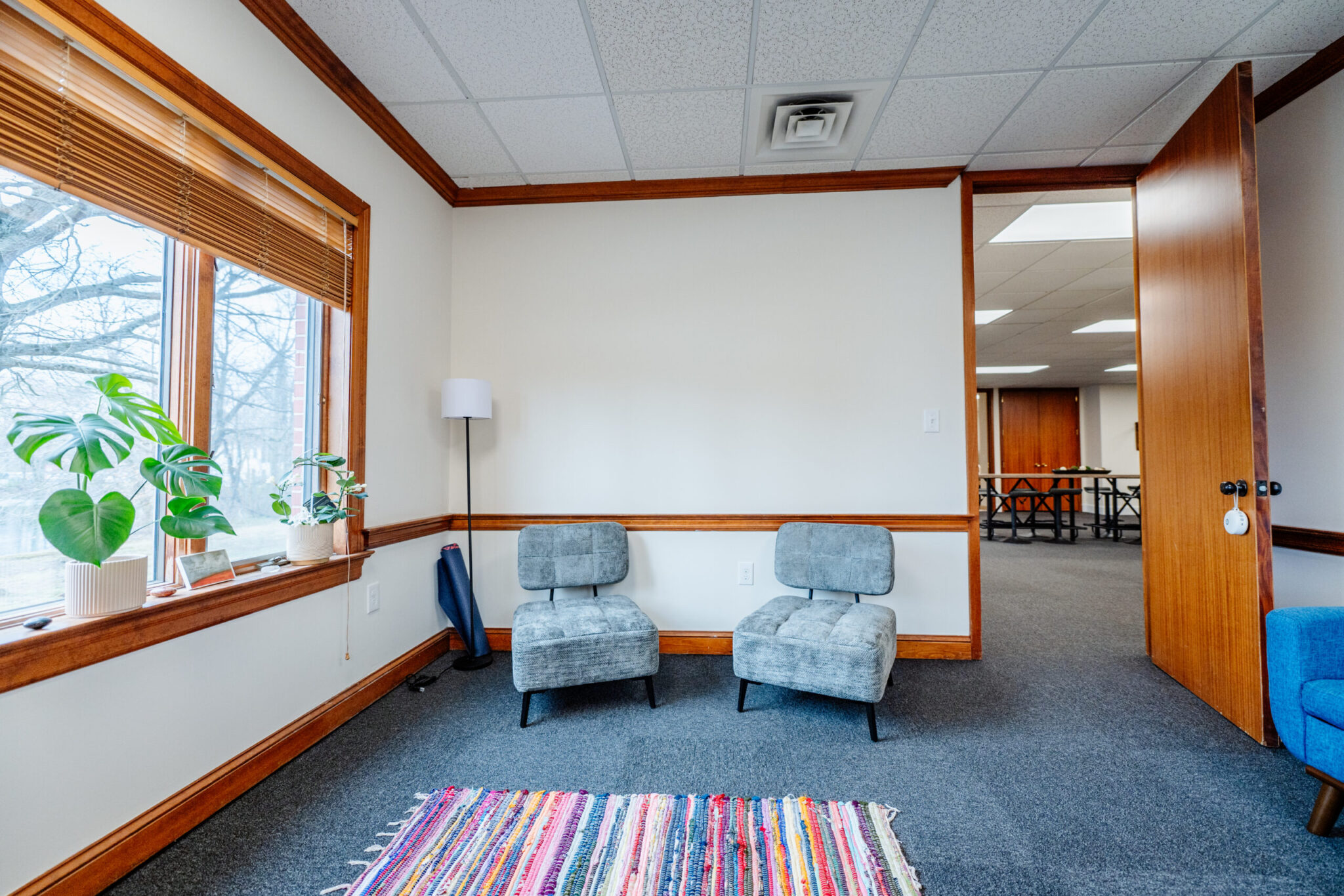 Cozy waiting room with chairs, rug, and large window
