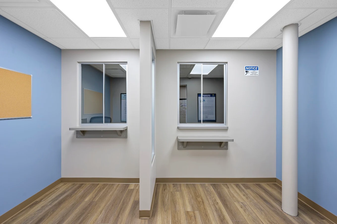 Patient check-in area with two service windows and blue walls