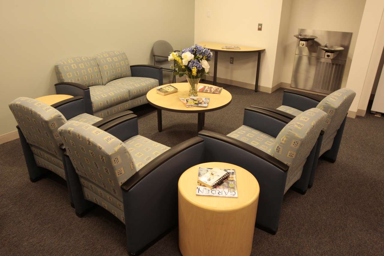 Patient lounge with chairs, tables, and refreshments