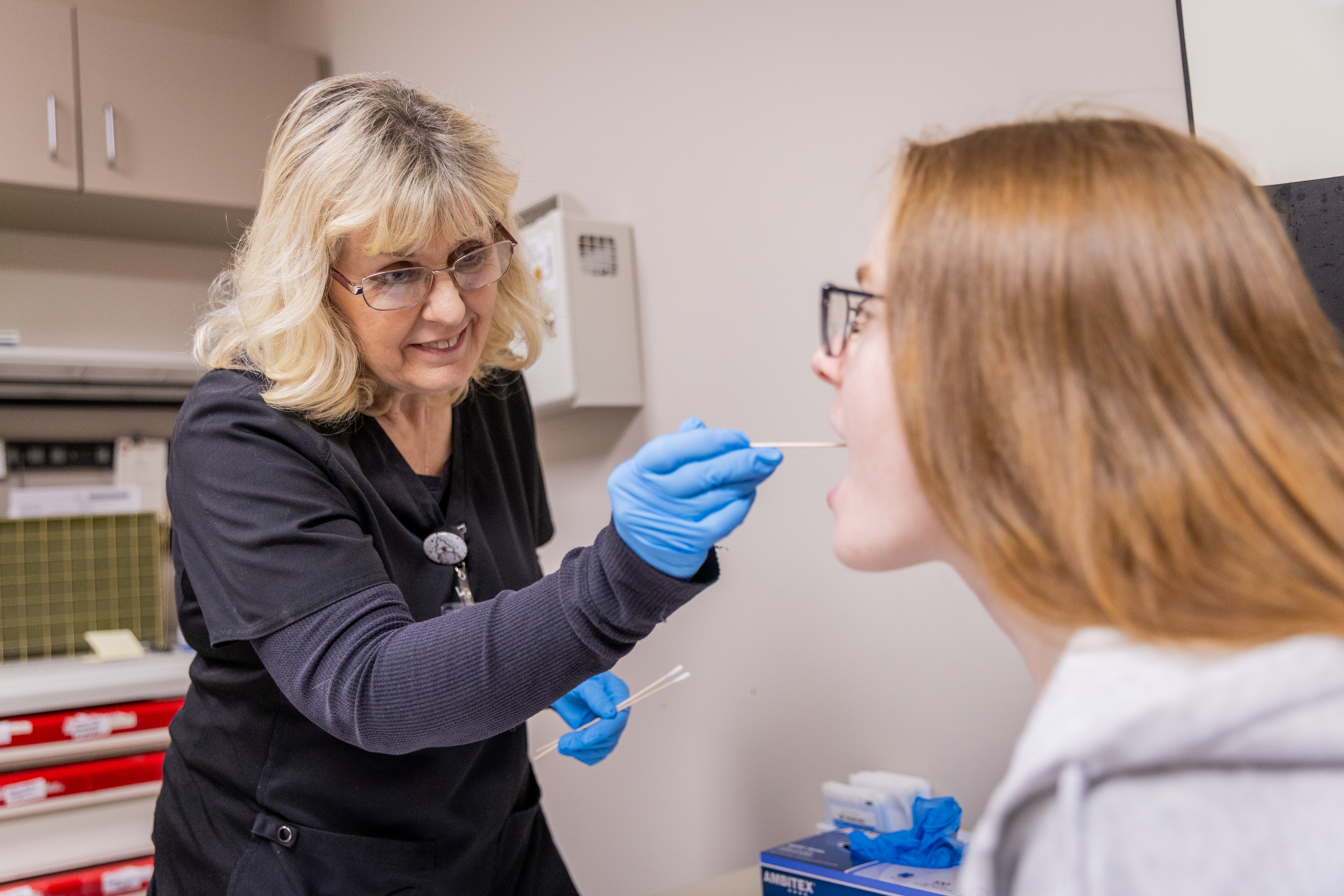 Nurse administering an oral swab test to a patient