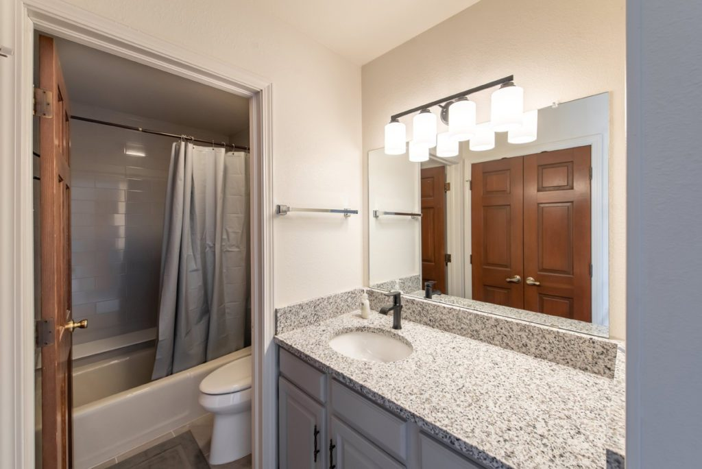 Bathroom with granite sink and shower curtain