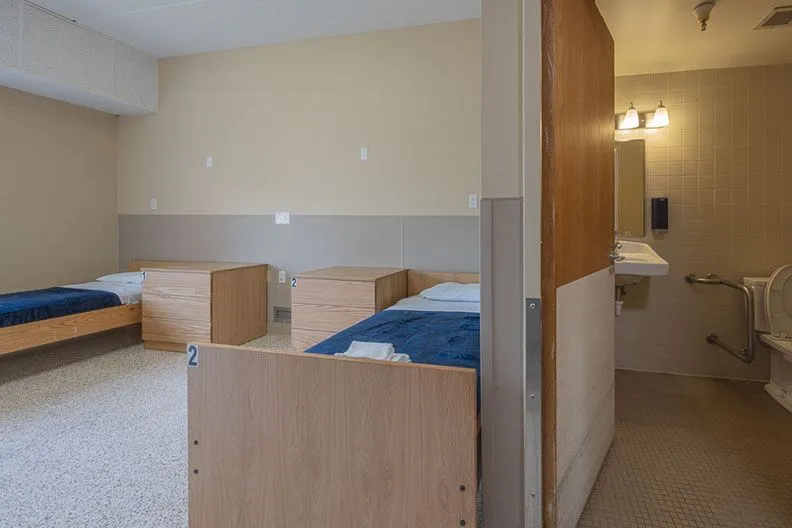 Shared bedroom with individual beds and nearby bathroom