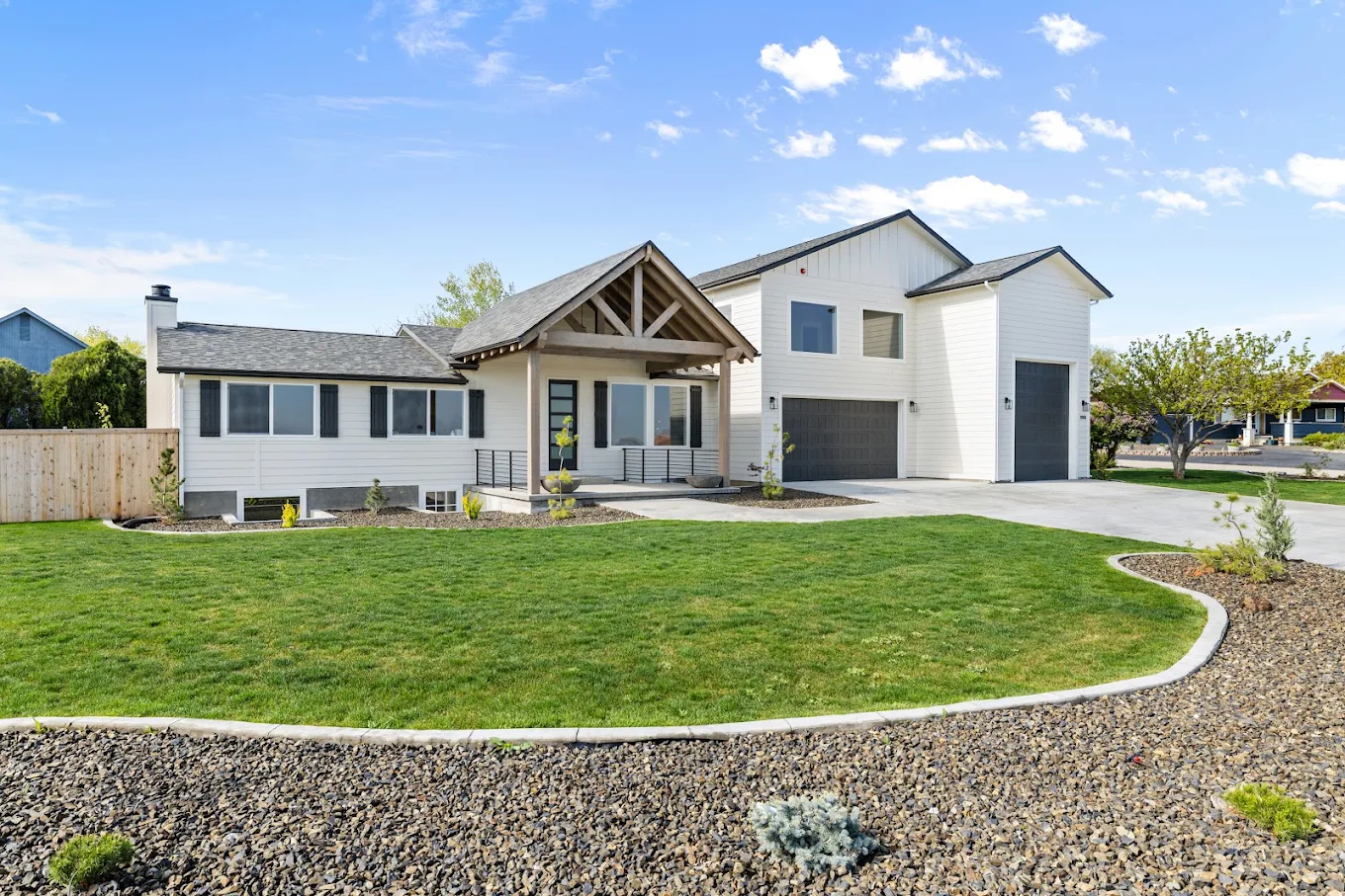 White recovery residence with green lawn and attached garage