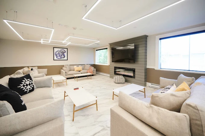 Modern lounge area with sofas, fireplace, and wall-mounted TV