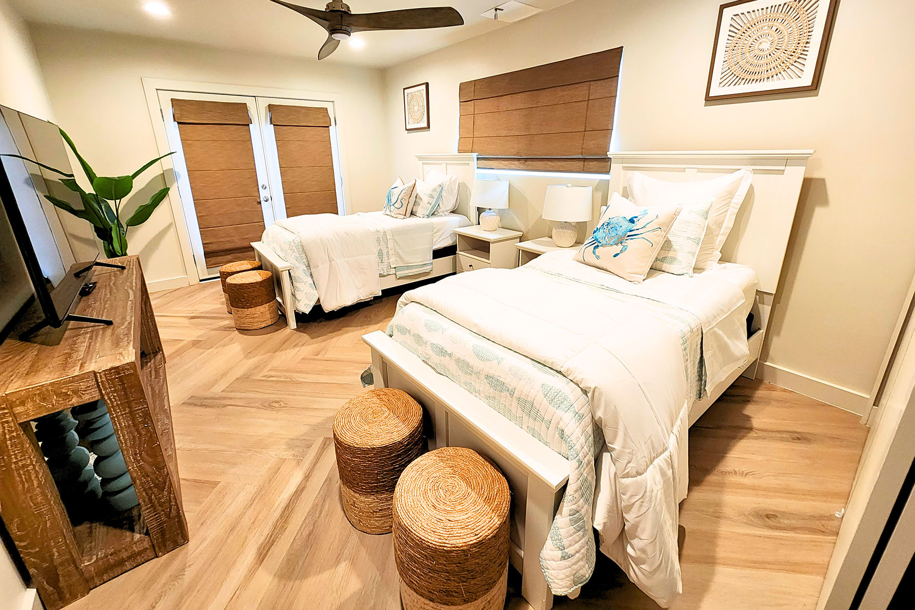 Twin beds with coastal décor and woven stools