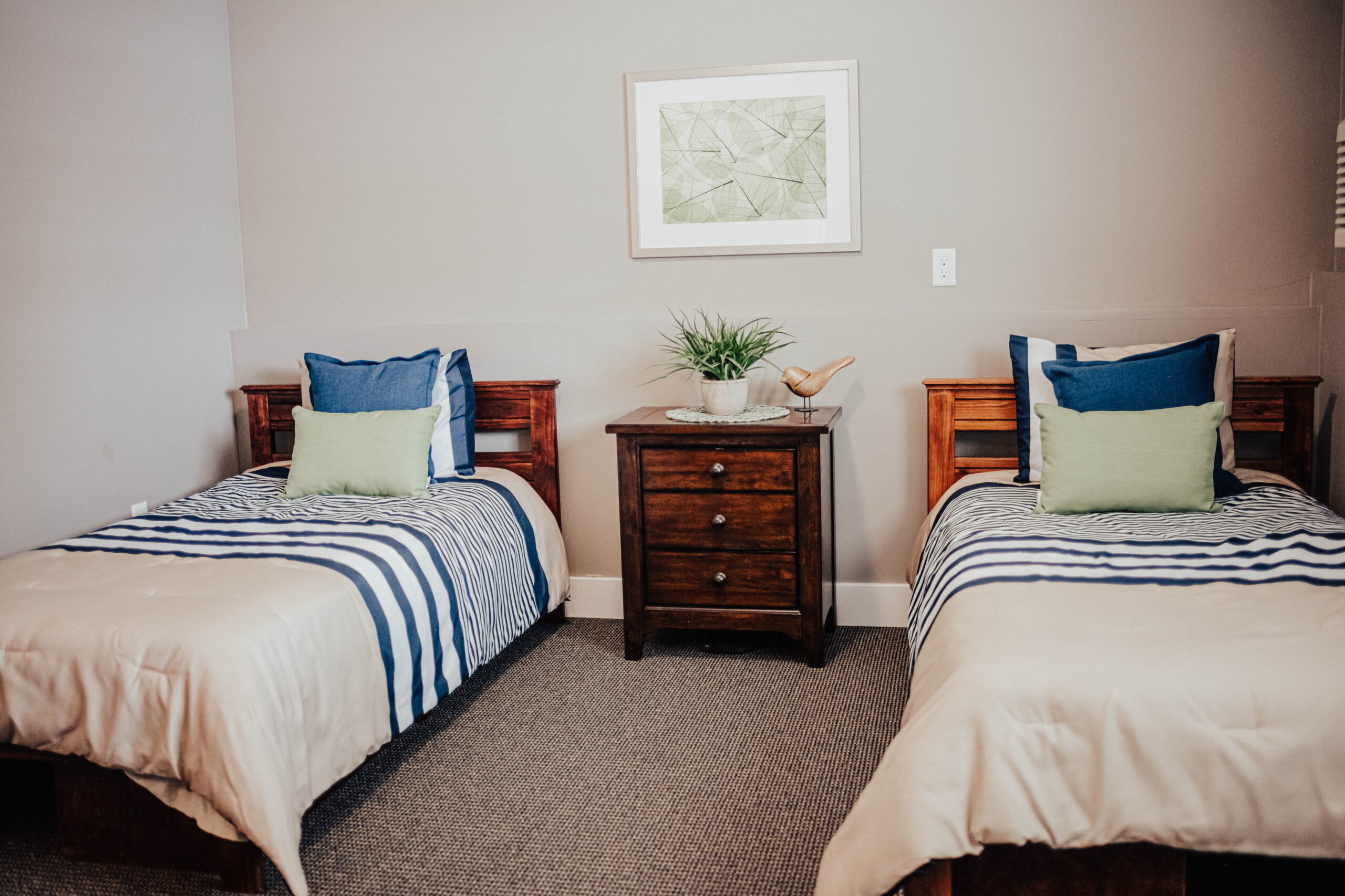 Two twin beds with shared nightstand and decor.