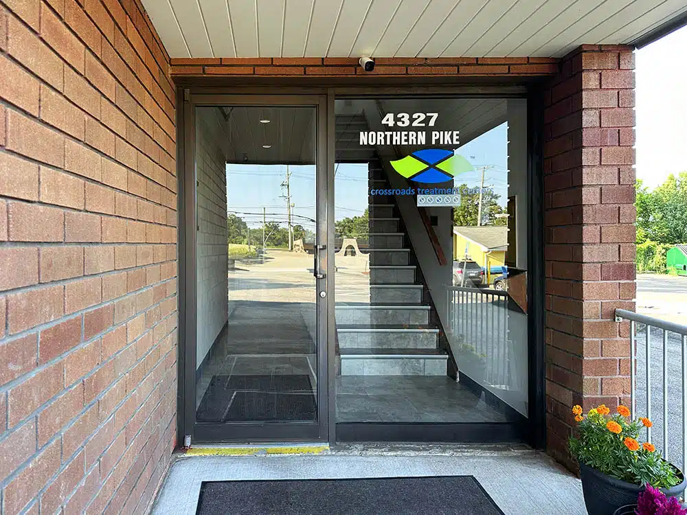 Glass entry door with Crossroads sign and address