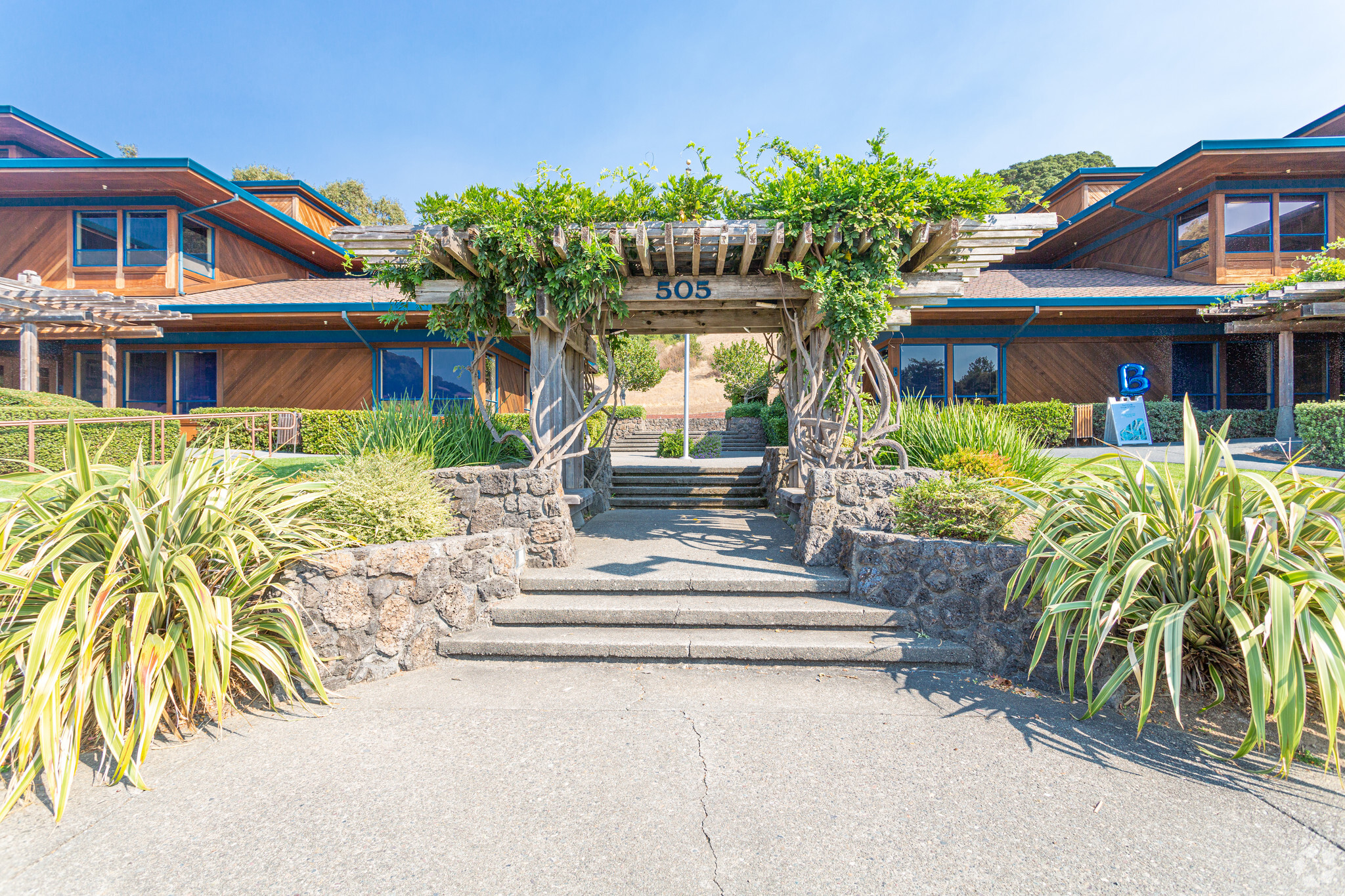 Arched entry with wooden pergola and stone steps