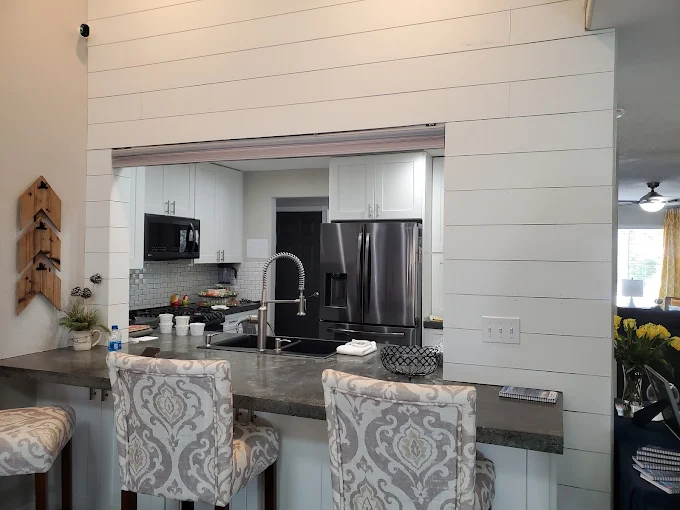 Modern kitchen with bar seating, stainless appliances, and sink