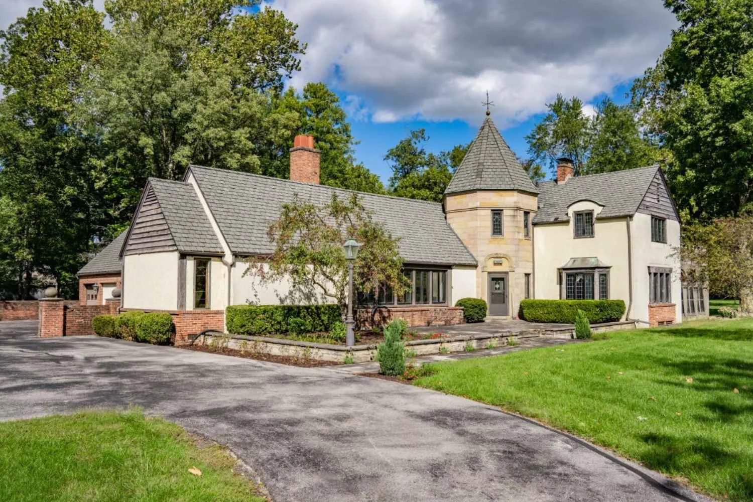 Tudor-style rehab facility with lush greenery and a peaceful setting.