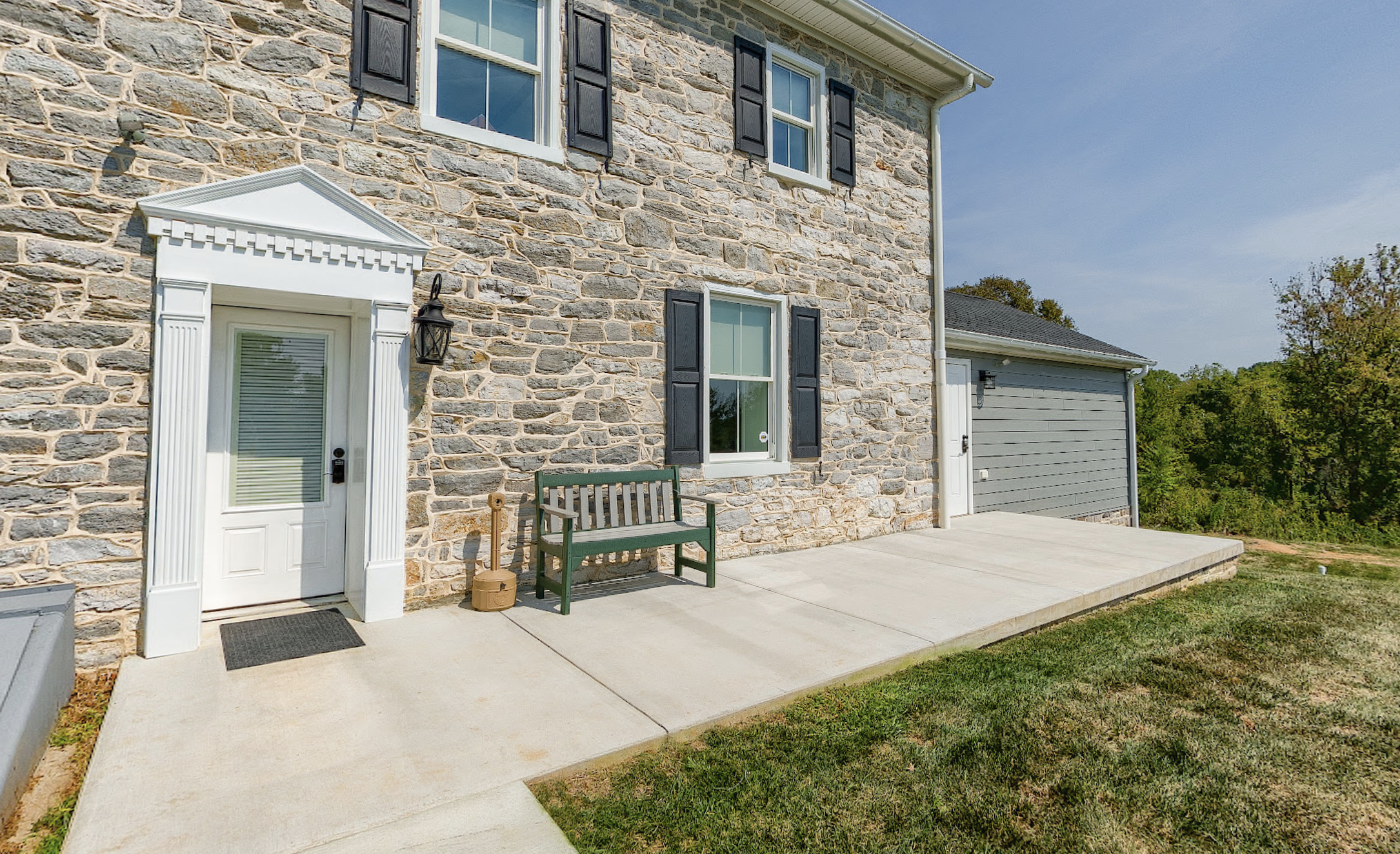 Stone building exterior with covered entrance and bench