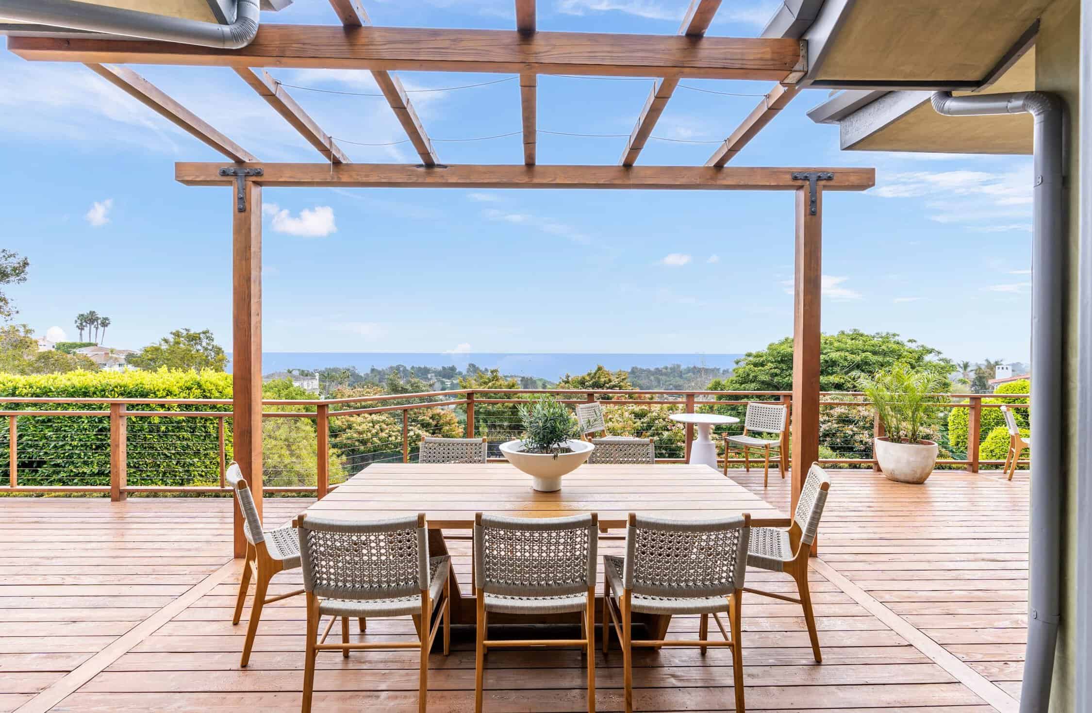 Outdoor dining patio with pergola and ocean views