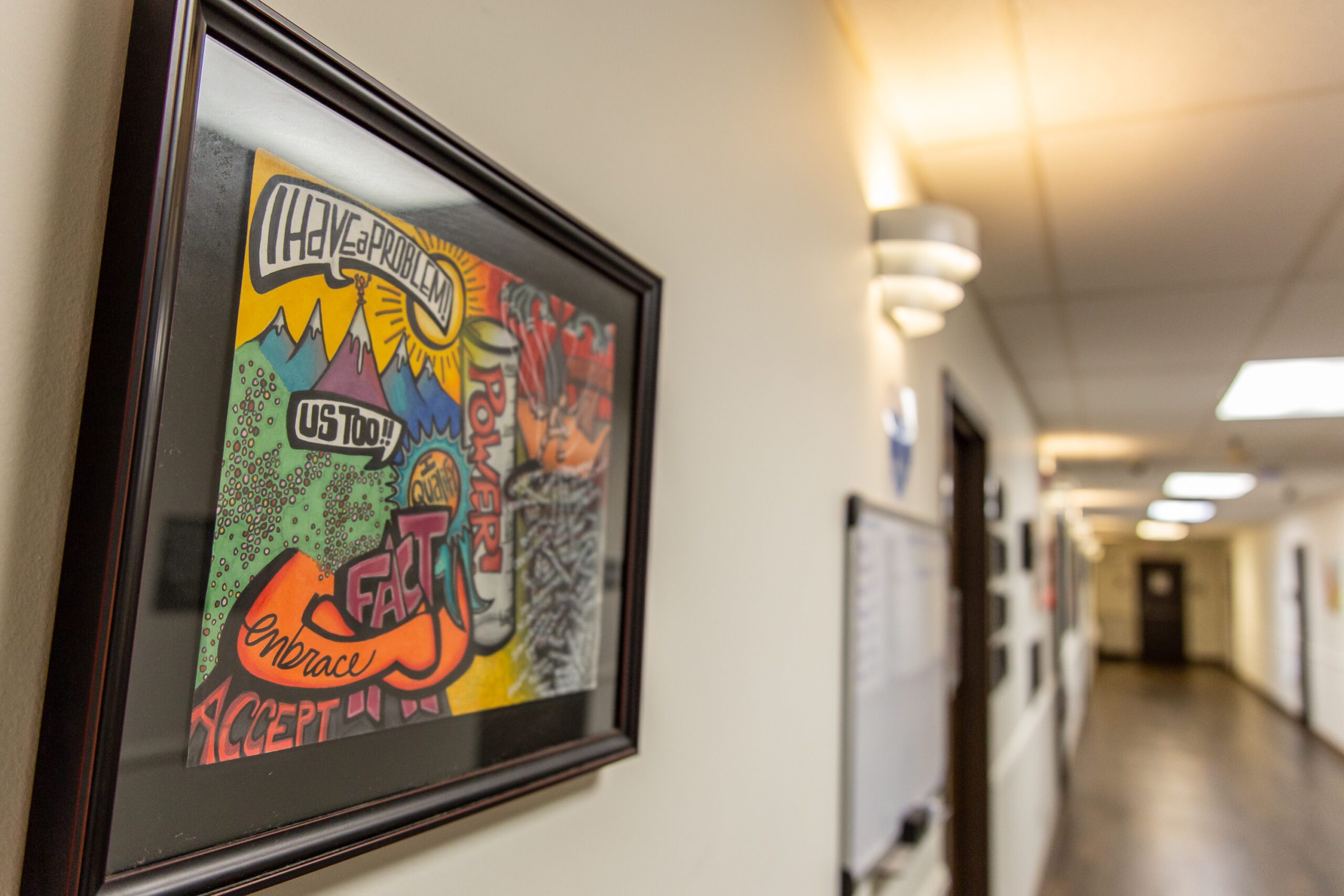 Framed recovery-themed artwork on a hallway wall