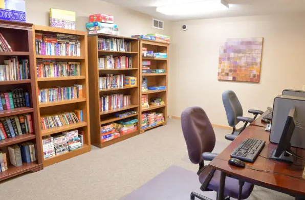 Library with bookshelves, board games, and computer workstations