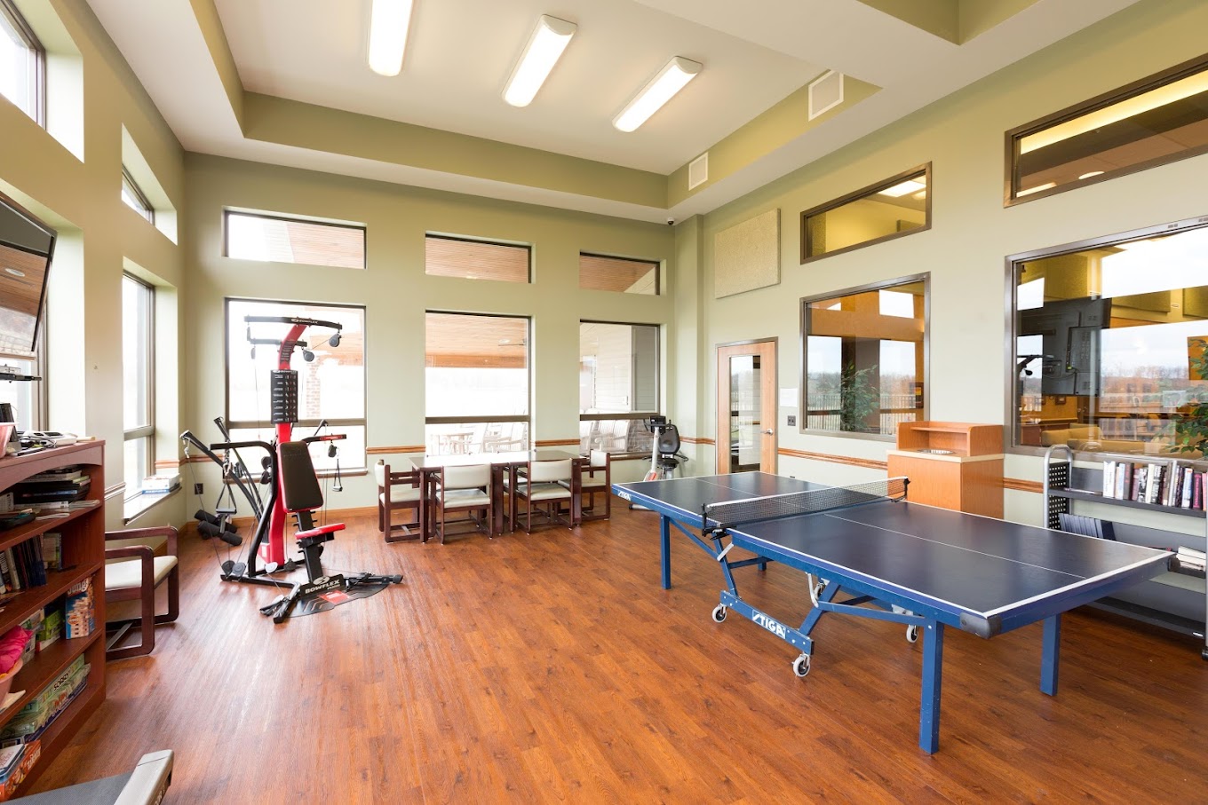 Rehab center game room with ping pong table and gym equipment