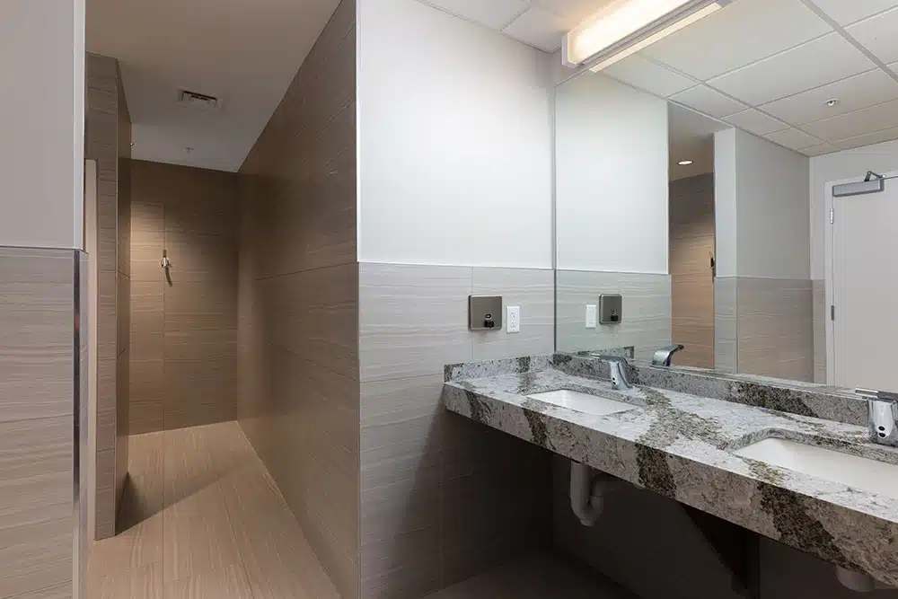 Dual-sink vanity and tiled shower area with soft lighting