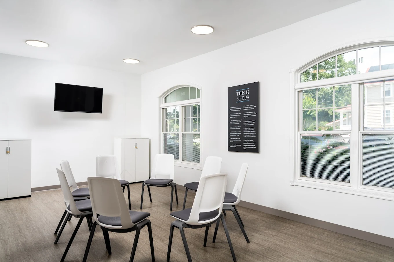 Group therapy room with white chairs and motivational posters