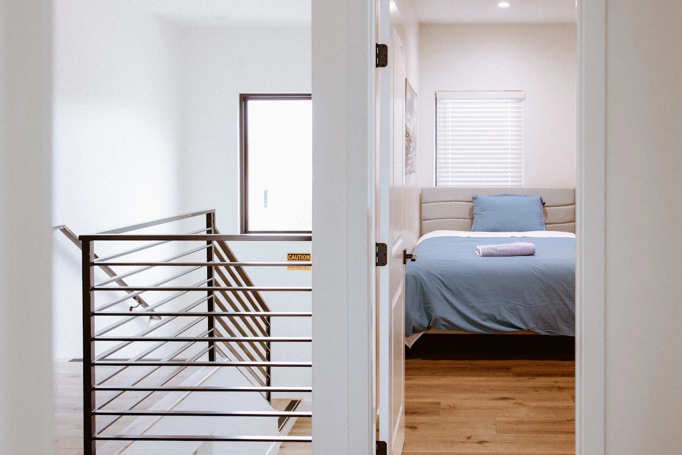 Hallway leading to a private bedroom with neatly made bed