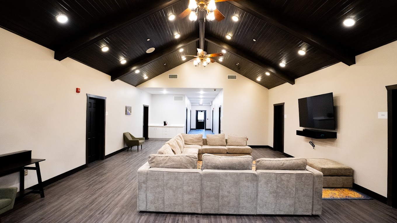 Rehab facility lounge with vaulted ceilings and soft seating.