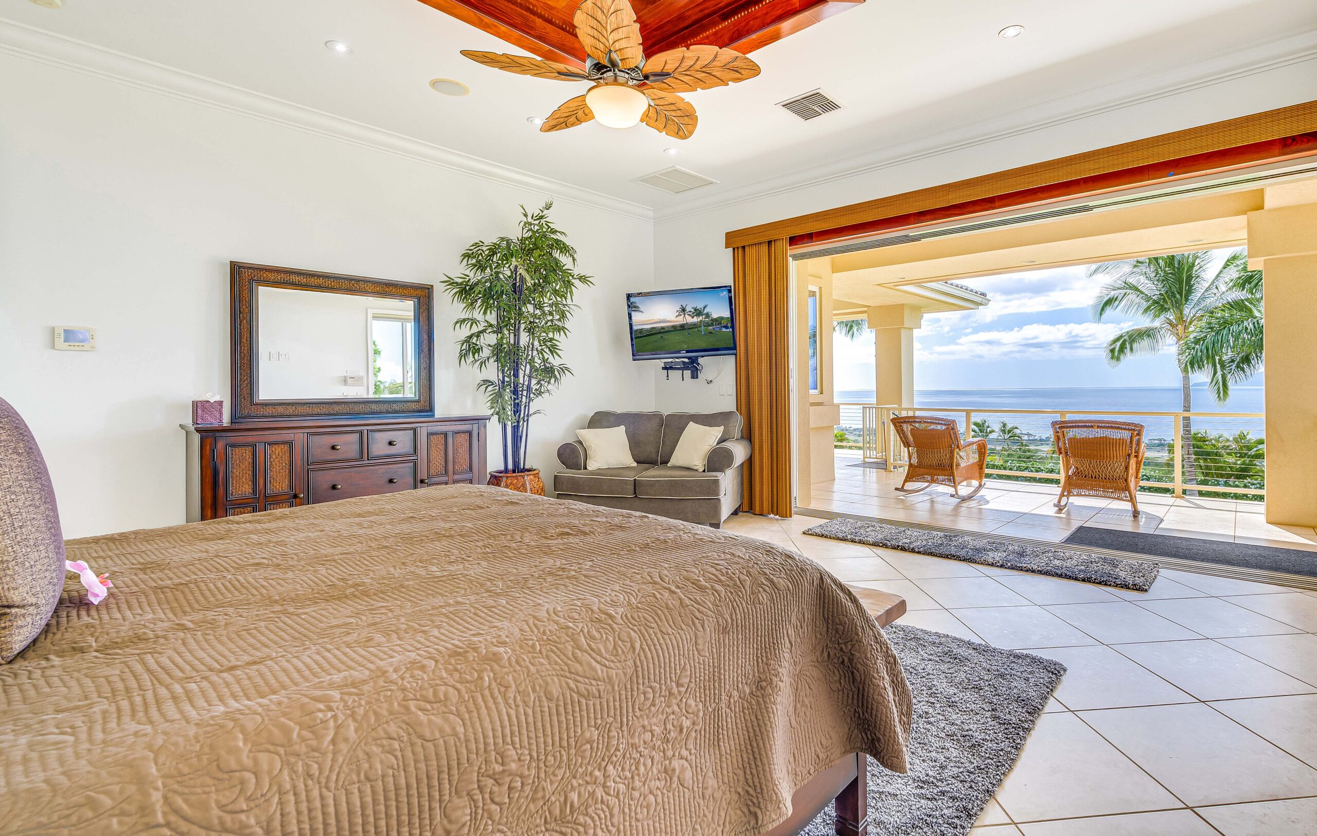 Private bedroom opening onto a covered lanai with panoramic ocean views