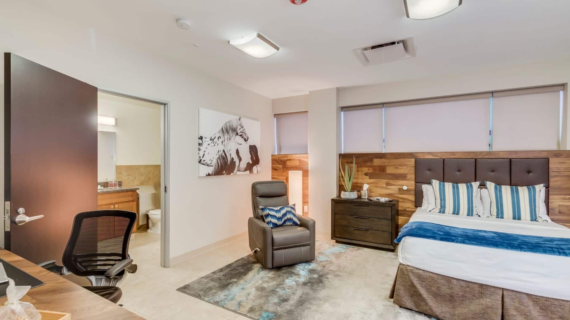 Private bedroom with bed, armchair and a in-suite bathroom.