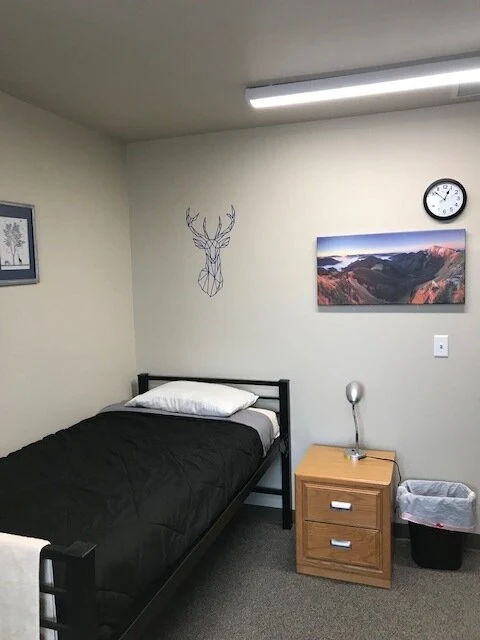 Private bedroom with twin bed, nightstand, and wall art
