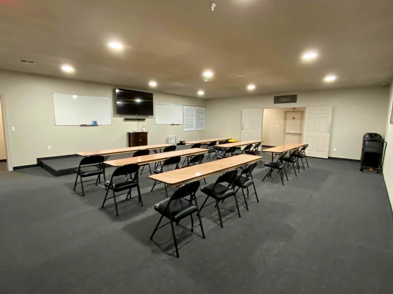 Group therapy room with tables, chairs, and presentation screen