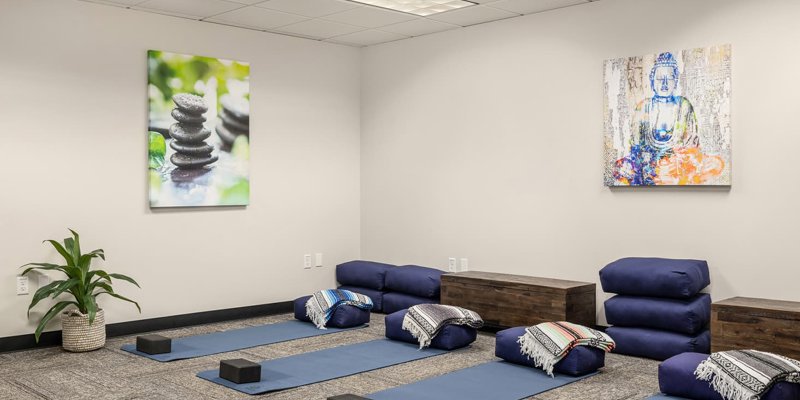 A serene yoga and meditation space with soft mats, cozy cushions, calming decor, and warm lighting, creating a peaceful atmosphere for relaxation.