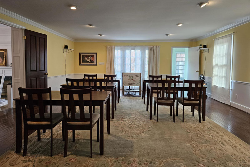 Yellow meeting room with tables and wooden chairs