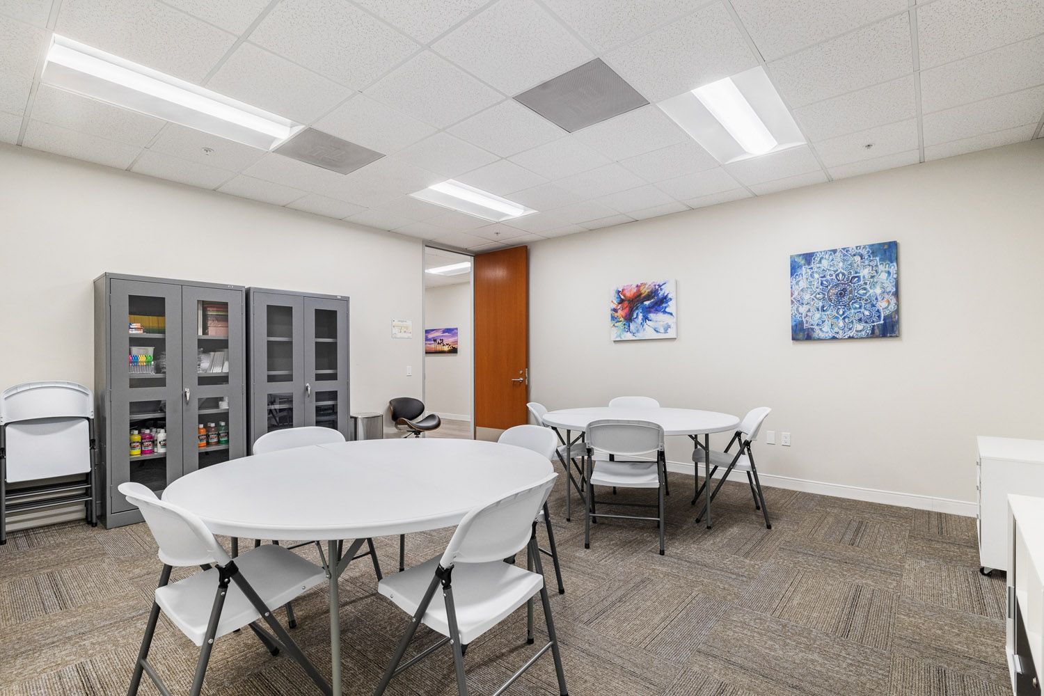 Art room with round tables, chairs, and storage cabinets