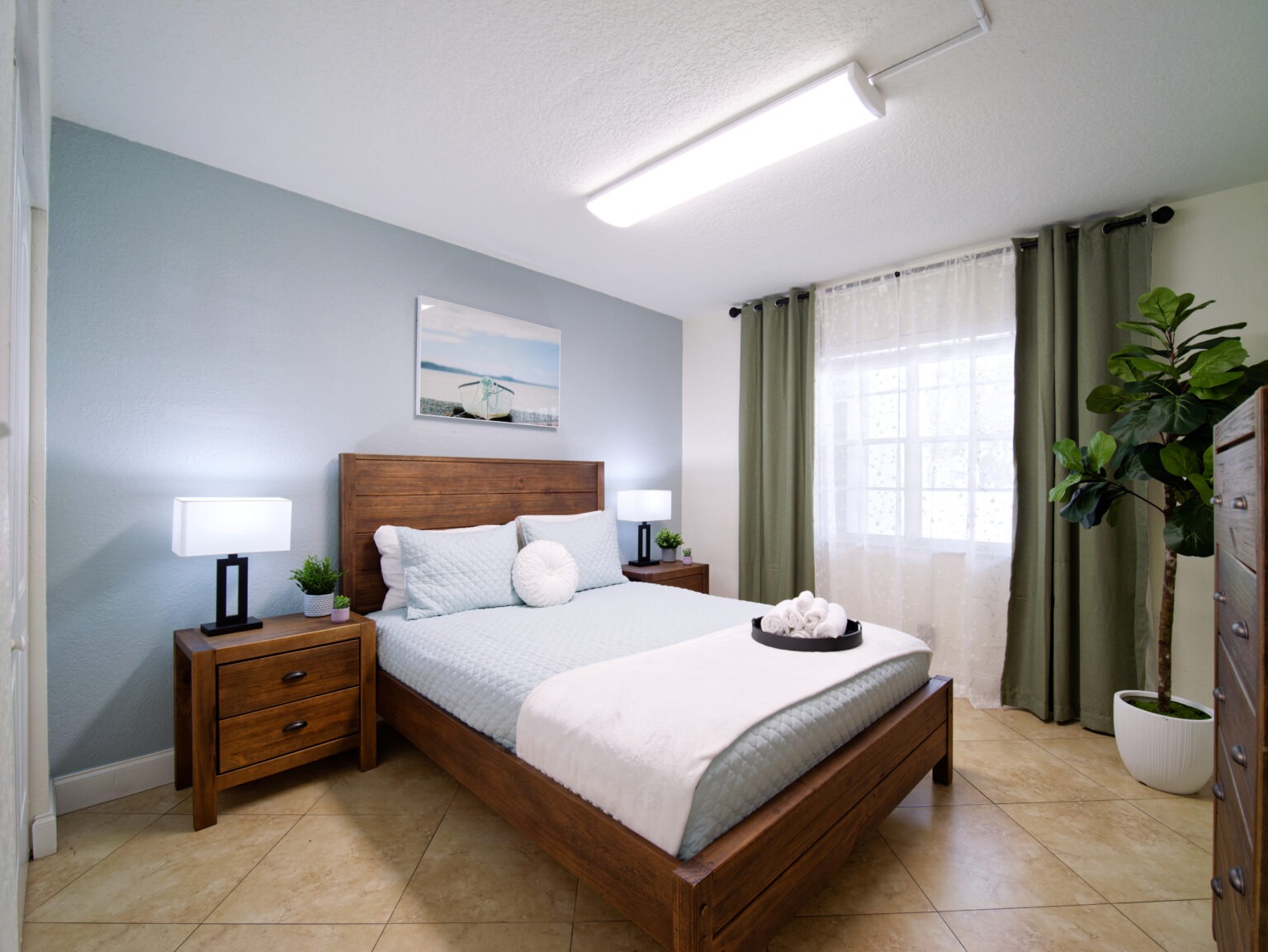 Cozy bedroom with wood furniture, soft bedding, and natural light.