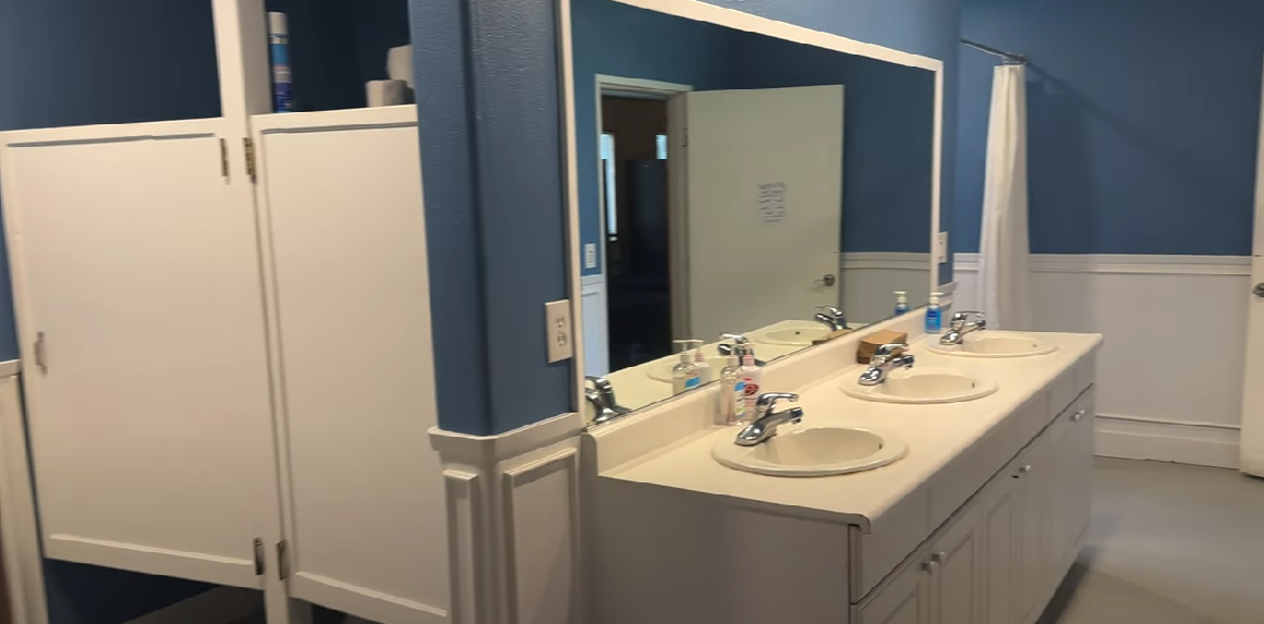 Clean bathroom with sinks, mirrors, and private stalls