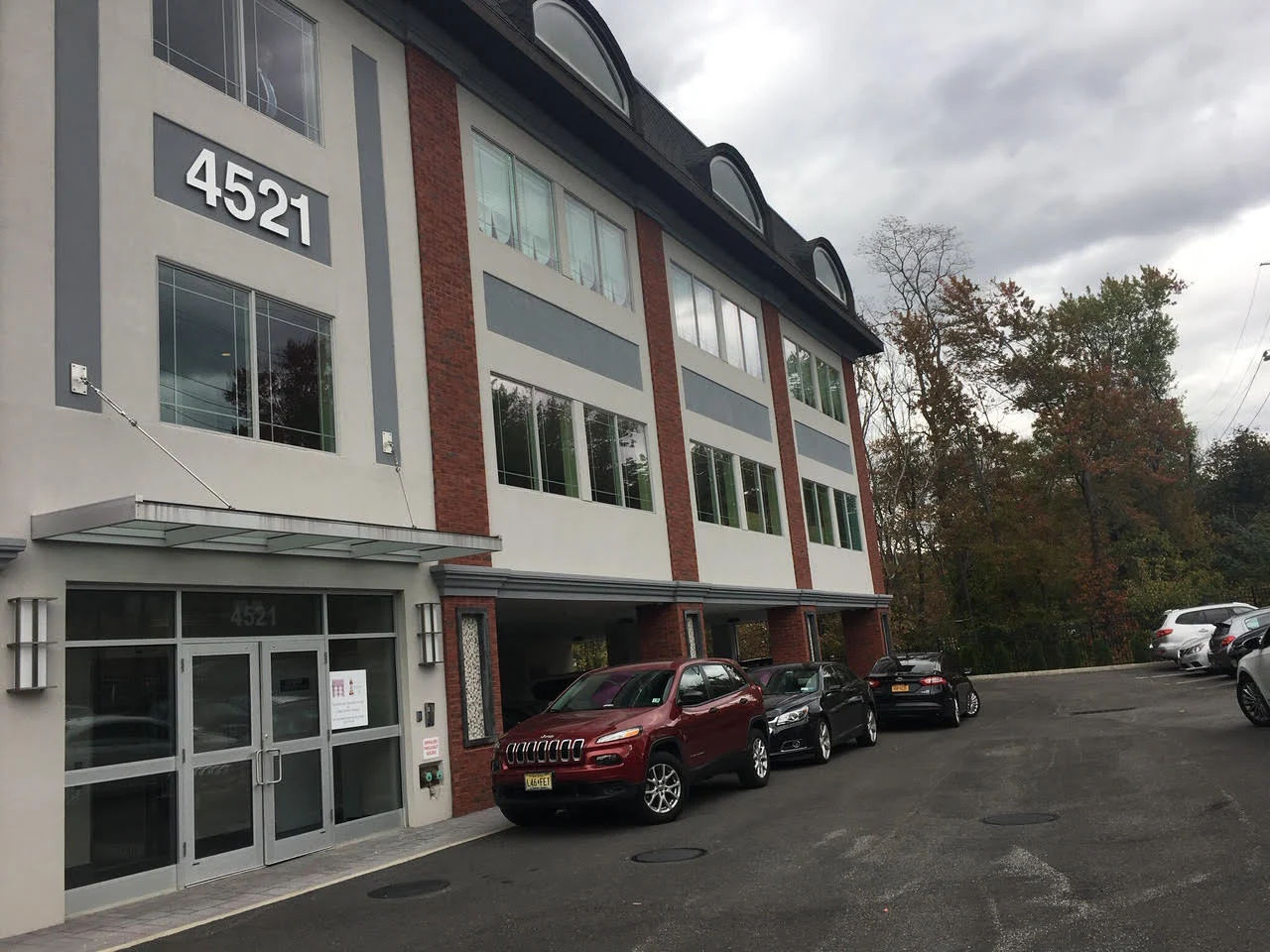 Front of facility with parking lot and cars