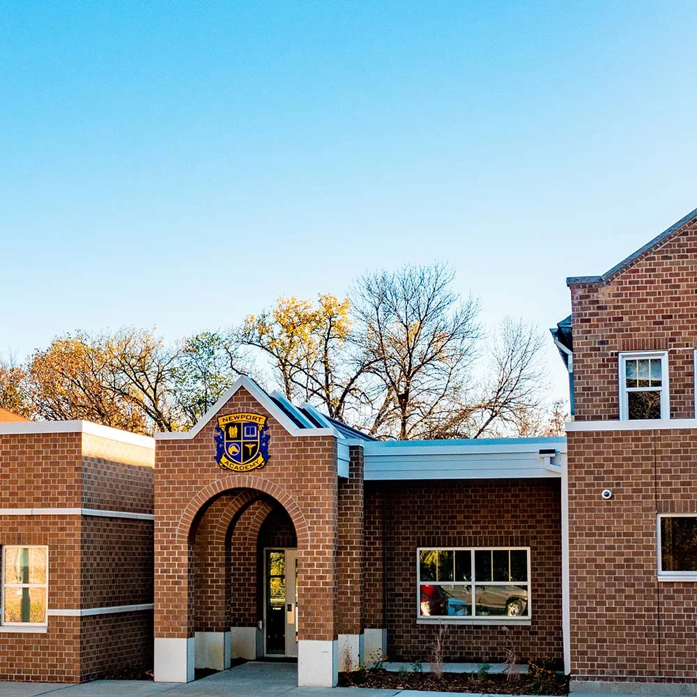 Brick building entrance with Newport Academy sign