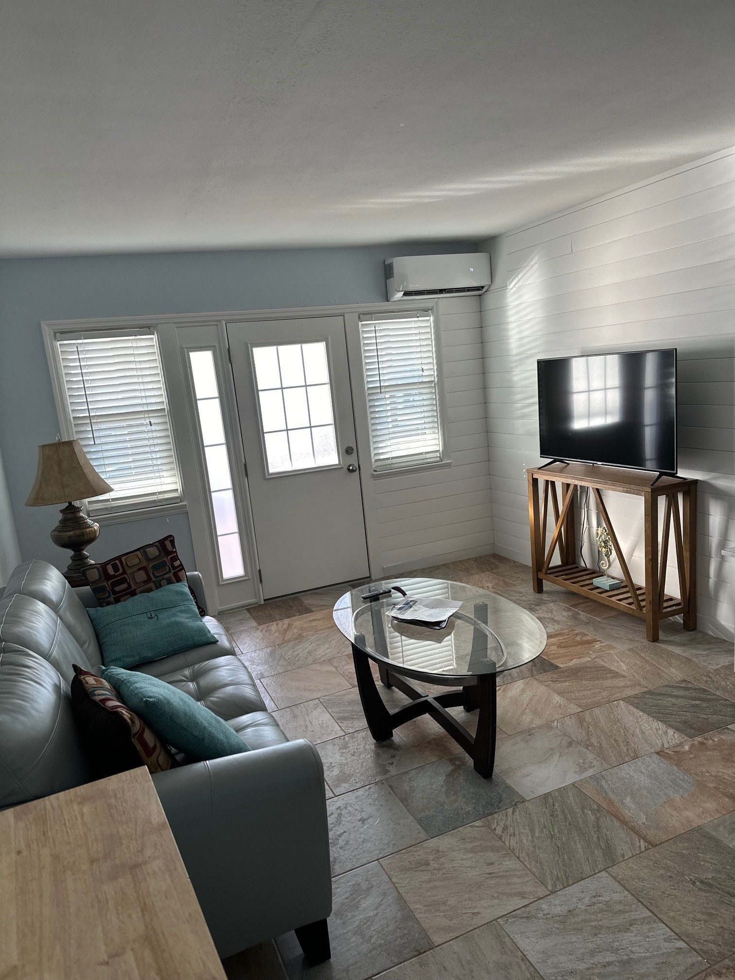 Cozy lounge with sofa, TV, and glass coffee table