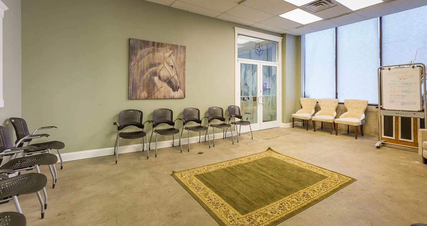 Group meeting room with chairs in a circle and green rug