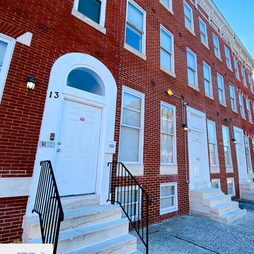 Brick building entrance with white doors and steps