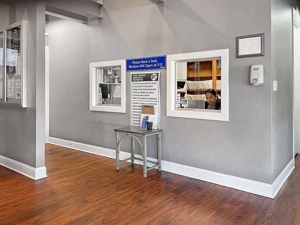 Reception window with staff and check-in area signage