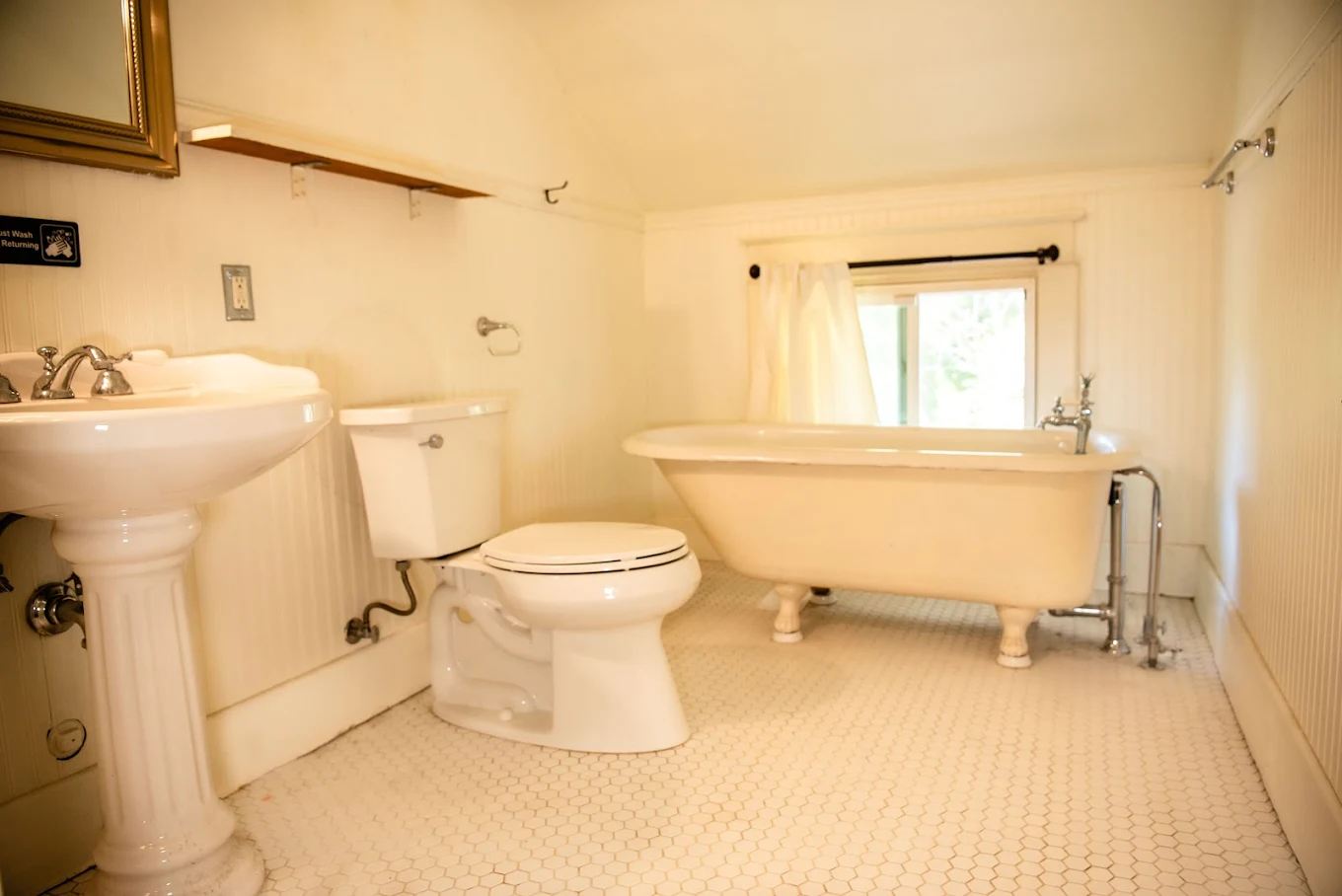 Vintage-style bathroom with clawfoot bathtub and pedestal sink