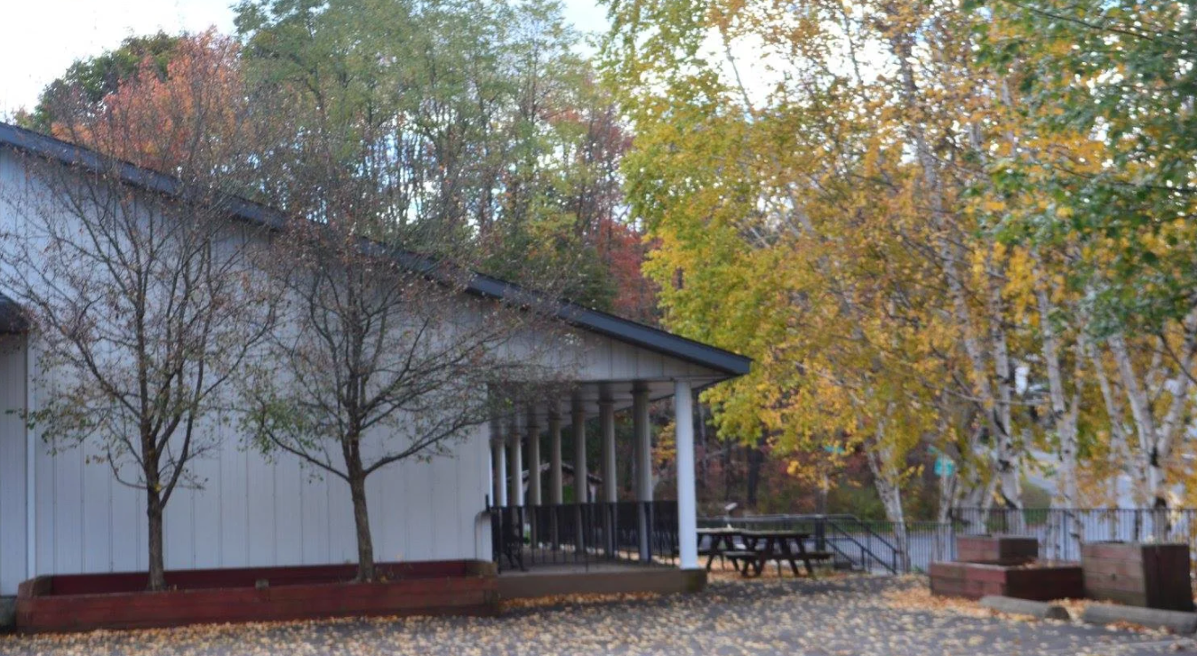 Exterior of treatment center surrounded by trees and outdoor seating