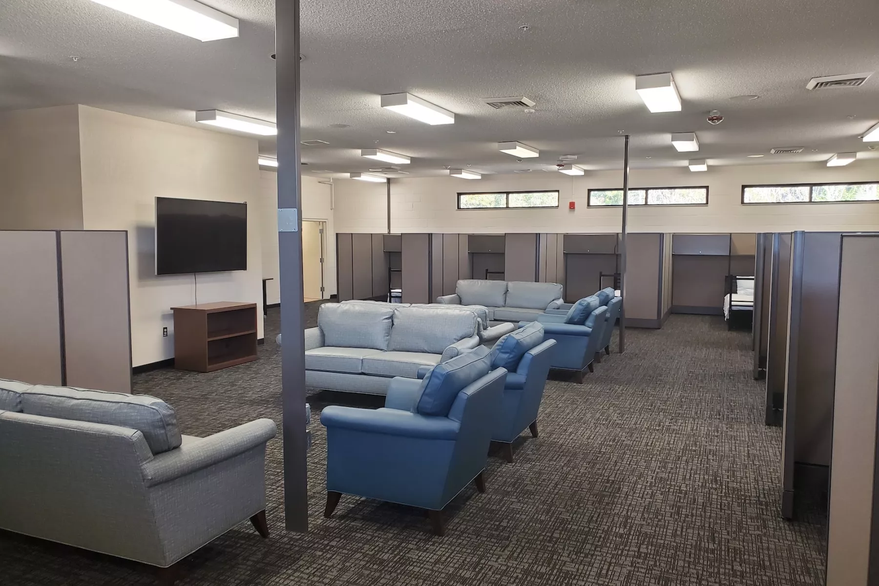 Spacious common area with sofas, television, and dividers