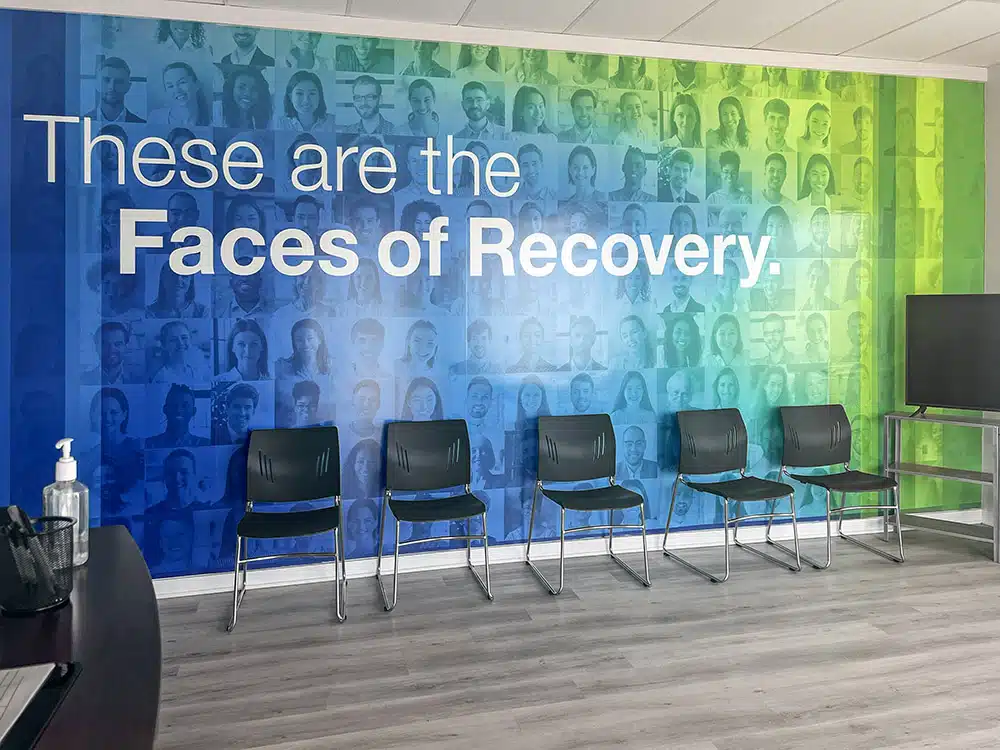 Chairs lined up in front of Faces of Recovery mural