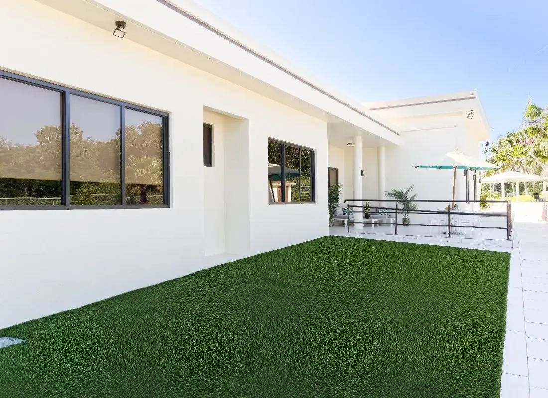 Exterior building with large windows and grassy outdoor area.