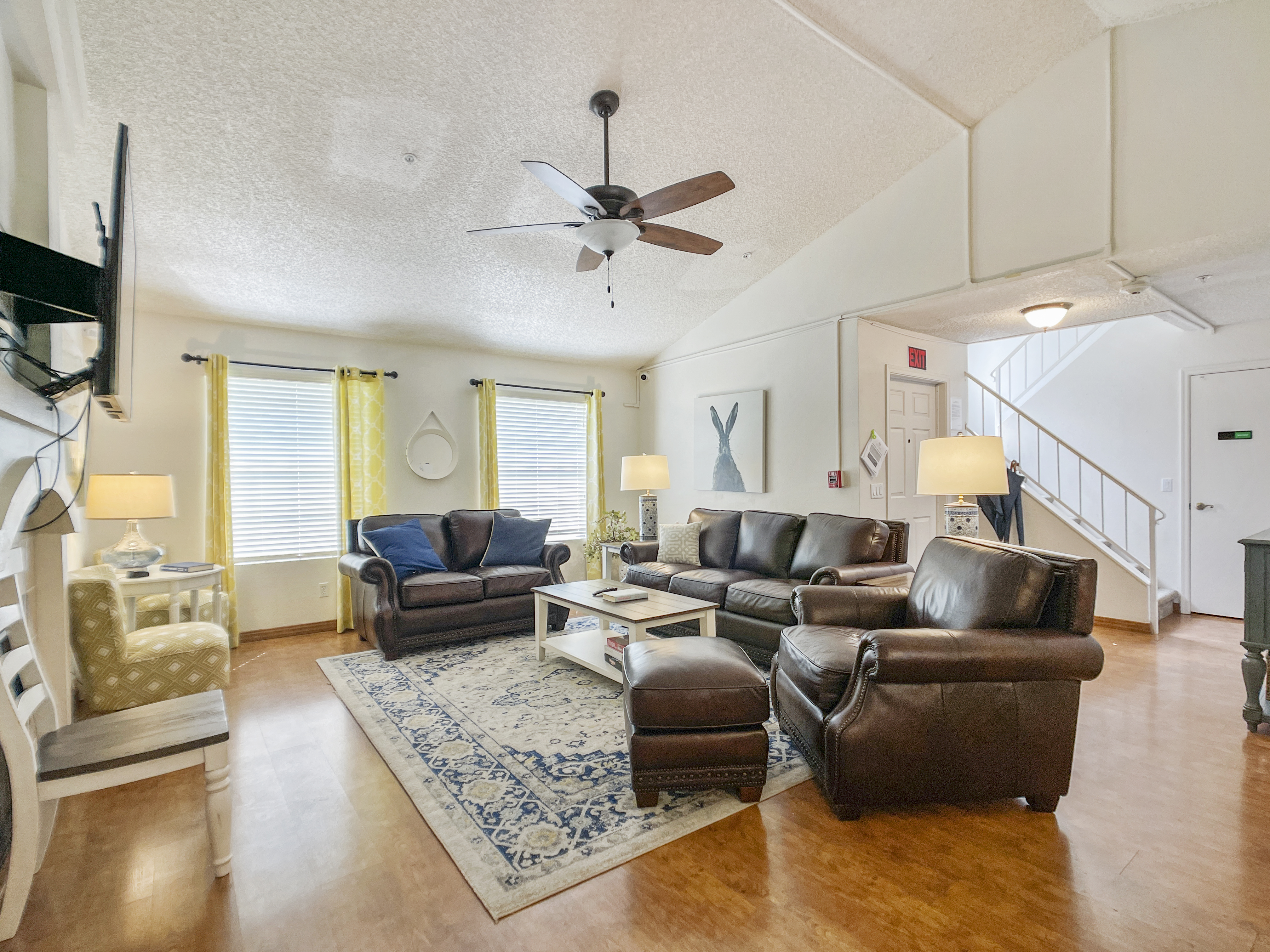Living room with brown leather couches facing a TV.