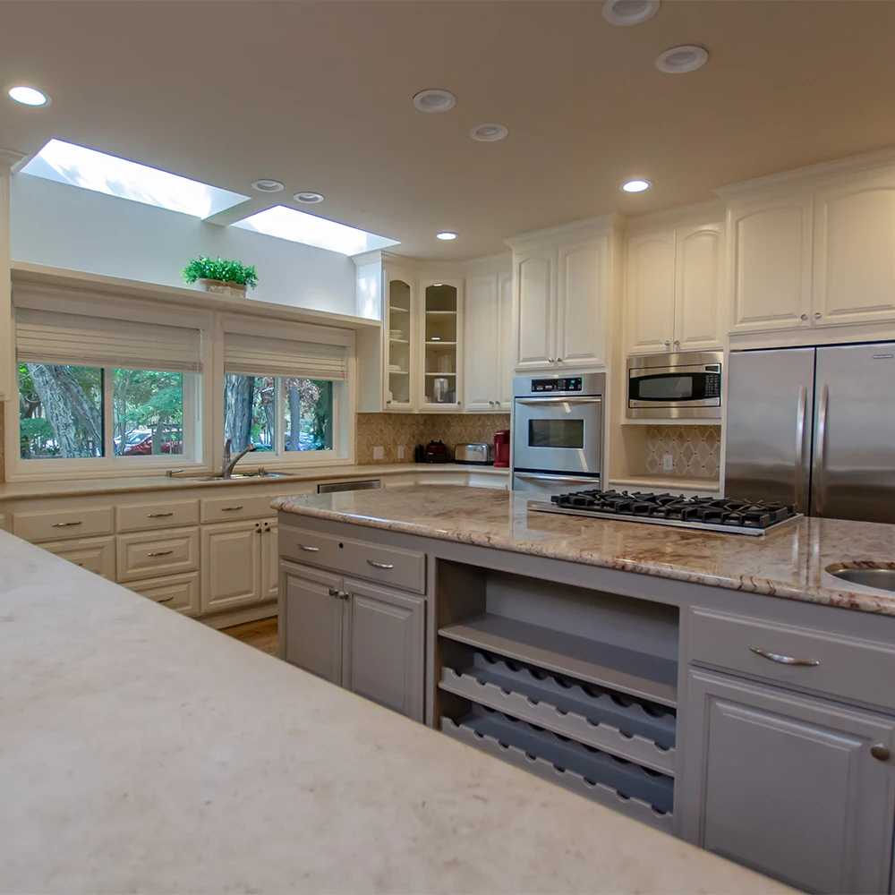 Bright kitchen with marble counters and skylights