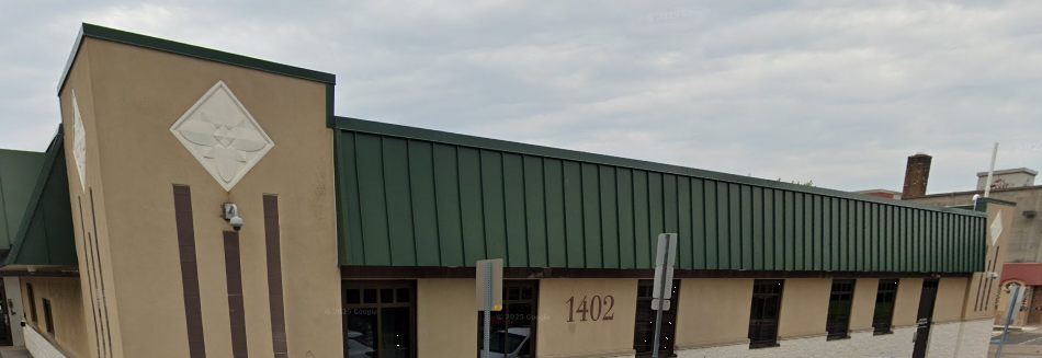 Exterior view of rehab center with green roof and tan walls