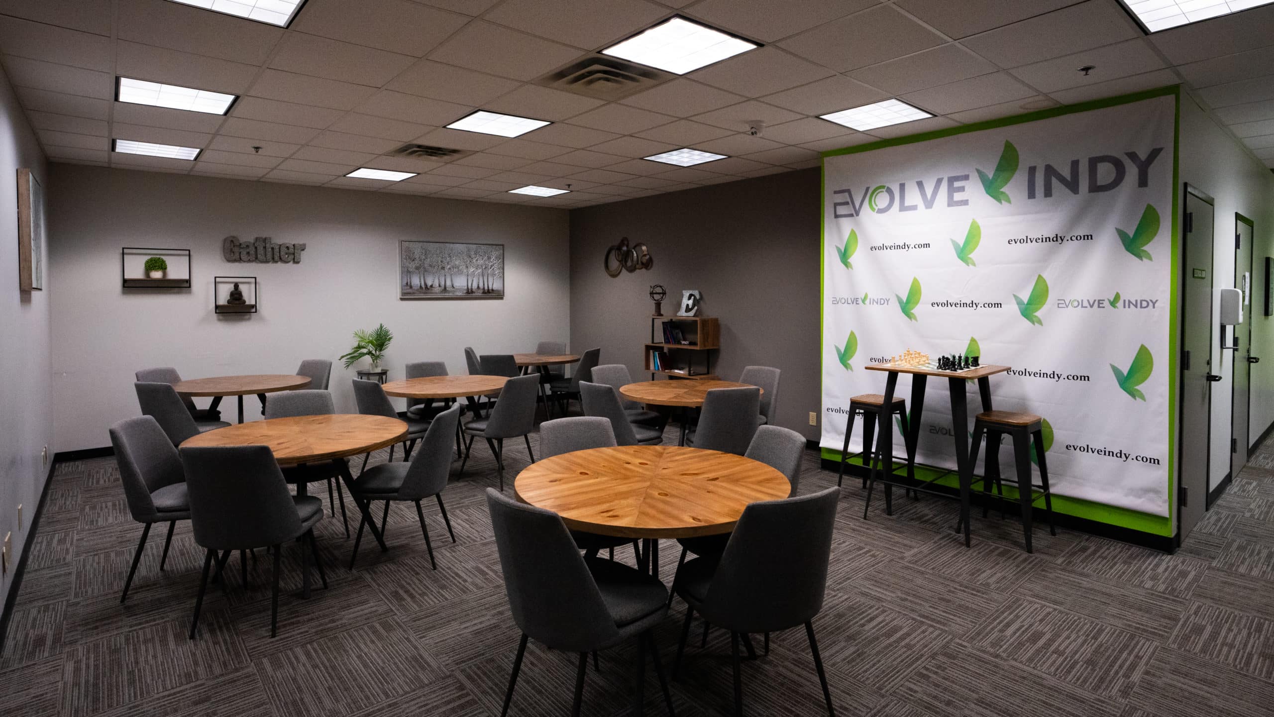 A communal dining area with black chairs and tables.